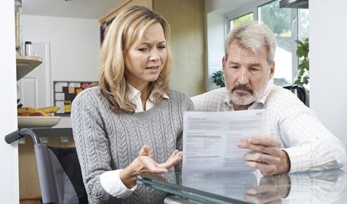 Frustrated Couple With Woman In Wheelchair Reading Letter