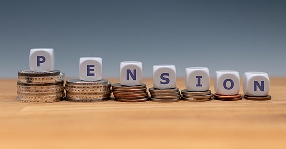 Symbol for decreasing pensions. Dice placed on stacks of coins form the word "PENSION".